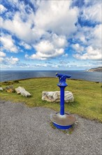 Viewpoint with blue telescope on the coast