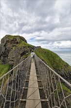 Narrow suspension bridge for pedestrians on rocky coast