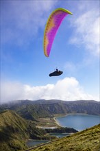 paraglider in flight over the crater lake Lagoa do Fogo