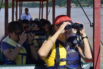 Tourist with binoculars in a longboat