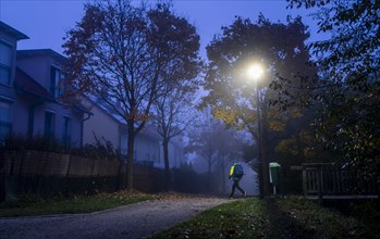Schoolchild in foggy weather on the way to school in Markt Swabia