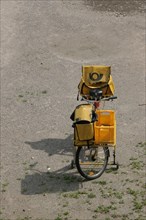Yellow postal bike with postal bag and front luggage holder