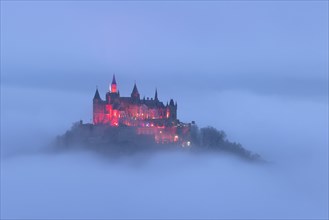 Hohenzollern Castle with Christmas lights above the fog