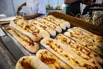 Long pizza bread with cheese and chourico sausage sold at Santa Iria Fair in Faro