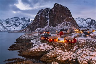 Winter Scandinavian landscape with illuminated red houses