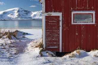 Red boathouse in winter Scandinavian landscape
