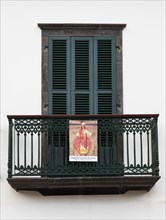 House facade with balcony and image of a saint