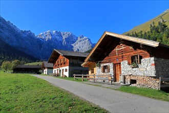 Alpine huts in front of mountain range