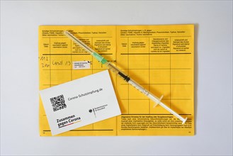 Syringe and vaccination card with entry with 1st vaccination with AstraZeneca against Covid-19