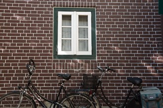 Dutch bikes leaning against red brick wall