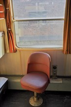 Red single seat inside an old train compartment