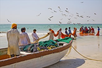 Fishermen hauling in nets on the beach
