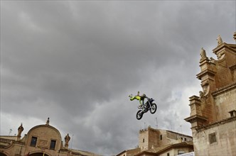 Flying motorbike artist above the rooftops of the old town