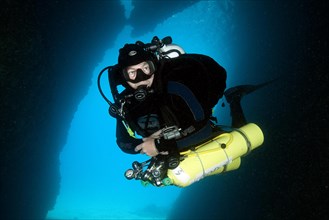 Diver does cave dive wearing special equipment with stage tanks