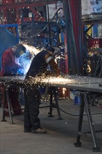 Workers in a factory working with metal on the shop floor