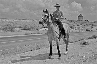 Lonely rider at the roadside with windmill in the background