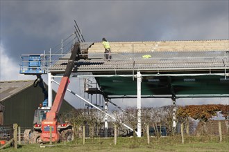 Builders putting roof on an agricultural building