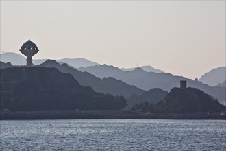 Coast near Muscat with view of fortifications and monument incense burner