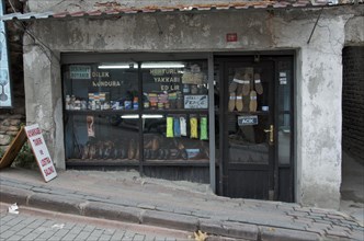 Old cobbler's shop with shop window on street with slope