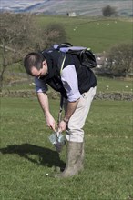 Agricultural expert taking soil samples for testing off a pasture in the Yorkshire Dales