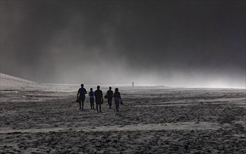 Group of people in the spray on the beach of Praia de Santa Barbara