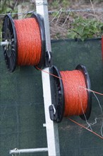 Electric fence wire on rolls around the edge of a field
