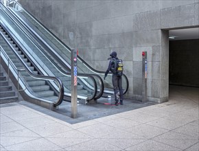 Man in diving suit at the escalator of Potsdamer Platz railway station