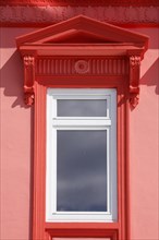 Ornate window on red house wall