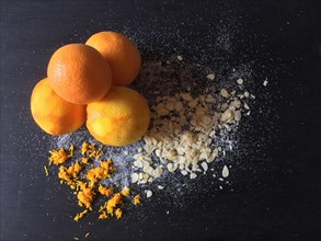Oranges with abrasion and almond slivers on slate board