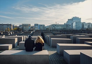 Young couple sitting on a stele of the Holocaust Memorial
