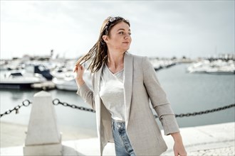 Portrait of young woman walking by marina in Faro
