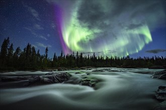 Northern Lights or Aurora Borealis over River Gamajahka or Kamajakka