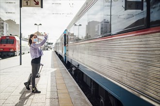 Waving and saying goodbye on the platform of train station