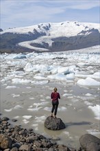 Woman standing in front of Fjallsarlon ice lagoon
