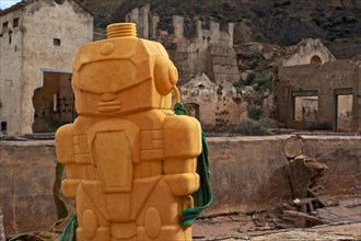 Yellow plastic figure in front of ruins of a mine in Mazarron