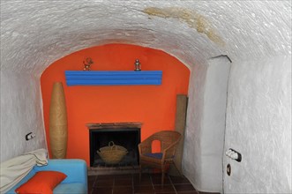 Room with orange wall and fireplace in cave house