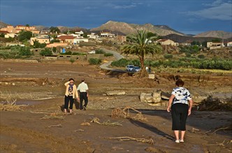 Residents of a village after the 2012 floods in front of a destroyed road