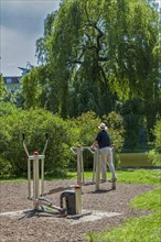Senior exercising on outdoor fitness equipment at Lietzensee Park