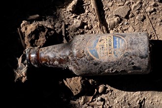 Dusty patina-covered beer bottle with logo on the clay bottom