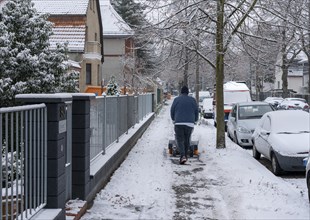 Caretaker removing snow and ice from a pavement