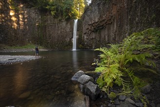 Young man in front of waterfall