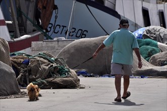 Master with dog on a leash in the harbour