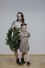 Mother and daughter with fir wreath