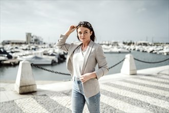 Portrait of young woman walking by marina in Faro