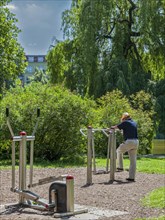 Senior exercising on outdoor fitness equipment at Lietzensee Park