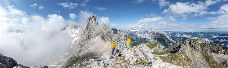 Two hikers in front of alpine panorama