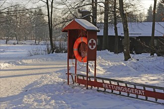 Red cottage with lifebuoy and ladder in the snow at Hinterbruehl Lake