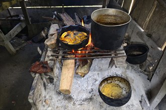 Fried bananas in a pan over a wood fire in a hut