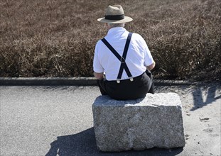 Senior sitting on a stone