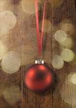 A red Christmas ball on a red ribbon
